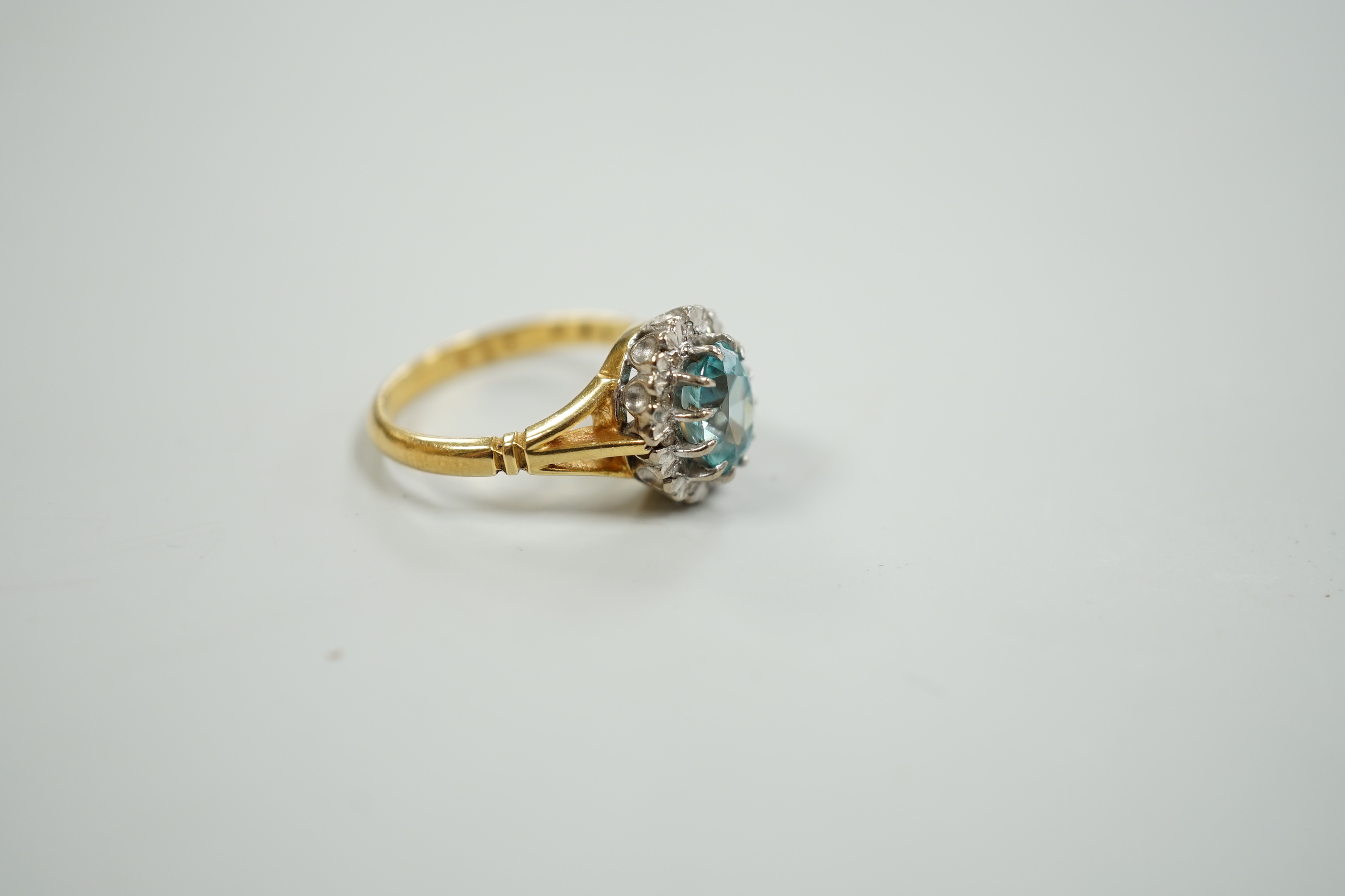 An 18ct, blue zircon and illusion set diamond oval cluster ring, size M, gross weight 5 grams.
